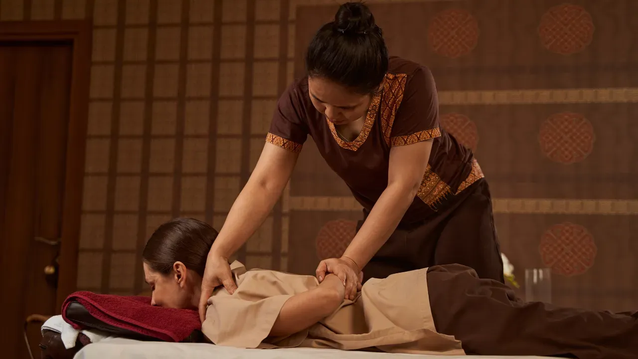 Assisted stretching during a fully clothed Thai massage